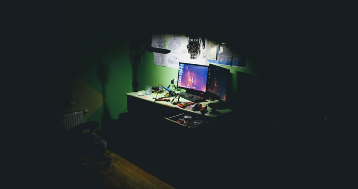 A flat-screen computer in a dark room.