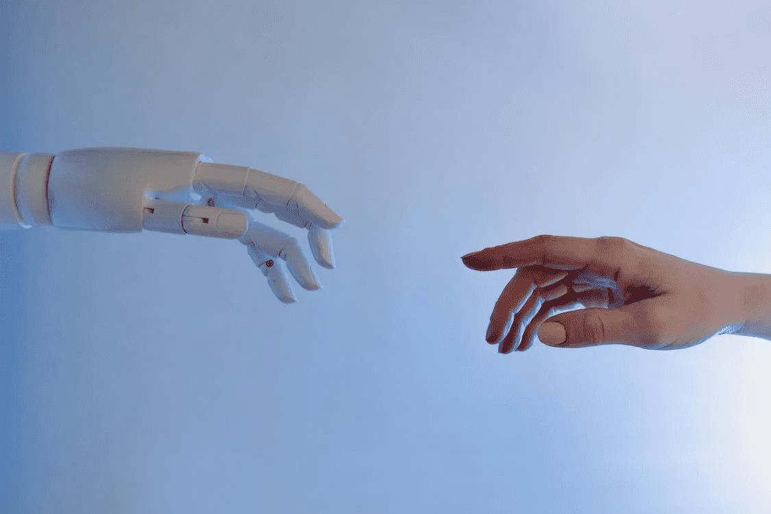 An image of a human hand reaching out to a robot
