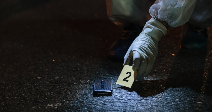 A mobile phone on a crime scene, labeled as evidence by forensics