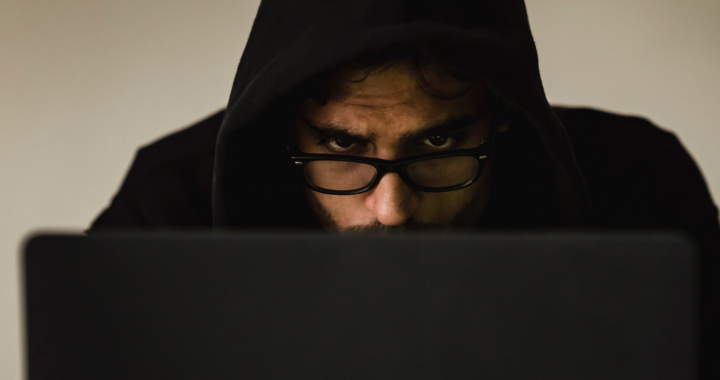 a person with a hoodie and laptop