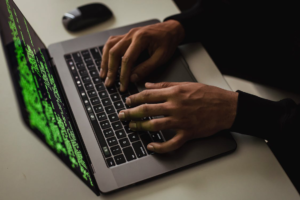 An image showing a person hacking via a laptop
