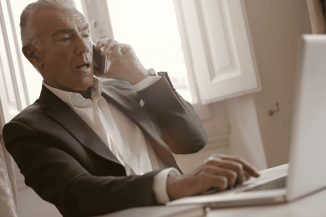 A businessman using their phone to make a call