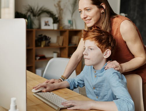 Woman teaching cybersecurity concepts to a boy