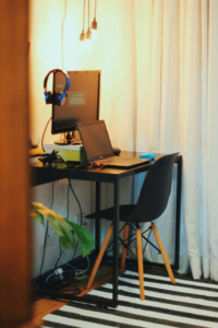 An image of a laptop and a computer on a desk in a room