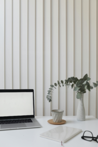 A laptop and a teacup placed on a white table