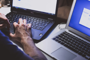 A man working on two laptops