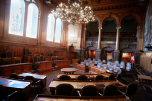 An empty courtroom with ornate woodwork and seating areas, where forensic video evidence is presented and expert witness testimony is given during legal proceedings.