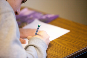 A person writing on a piece of paper. 