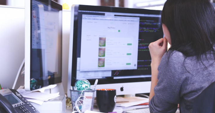 a female working on two computers simultaneously