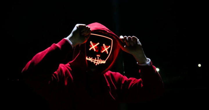 An image of a person wearing a mask and a red hoodie