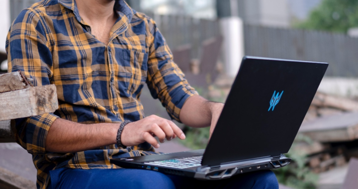 Man typing something on his black laptop