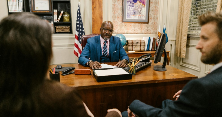 A judge sitting in a formal suit at his table