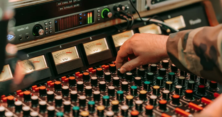 An image of a person using an audio mixing console