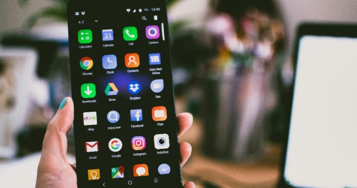 Person holding a lit-up mobile phone in their hand