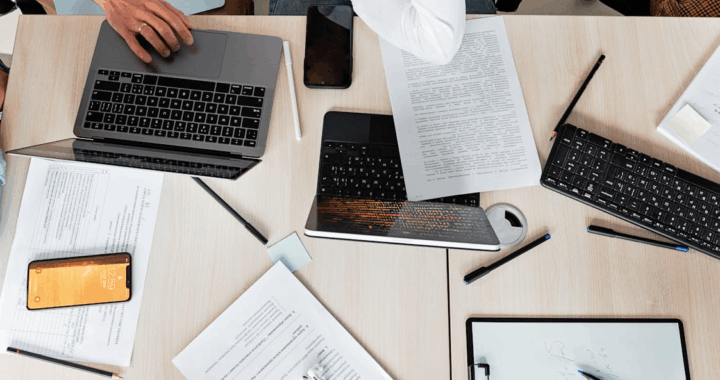 a group of people going through documents and digital records on their laptops
