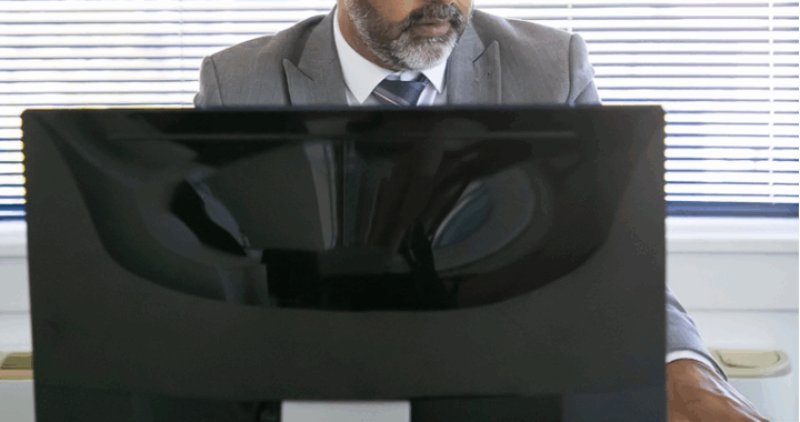 Video enhancement expert analyzing courtroom footage on a computer