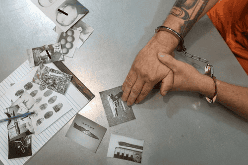 A handcuffed individual analyzing pictures