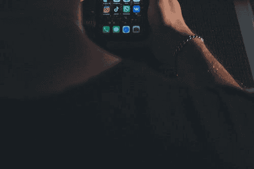 Hand holding a smartphone in a dark room