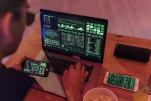 Examiner working on a laptop beside two smartphones displaying data