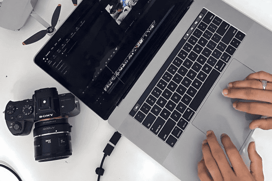 Camera, drone and laptop on a desk during a video footage review